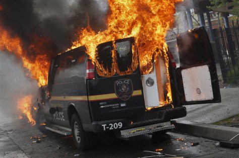 A Baltimore Metropolitan Police transport vehicle burns during clashes in Baltimore